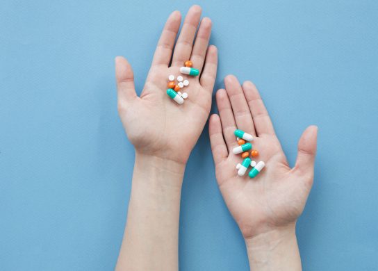 woman taking colorful supplements to treat illness,