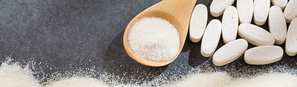 pill and a spoonful of powder on slate color background