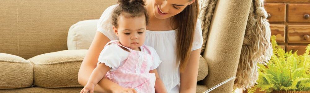 Small child reading with mother