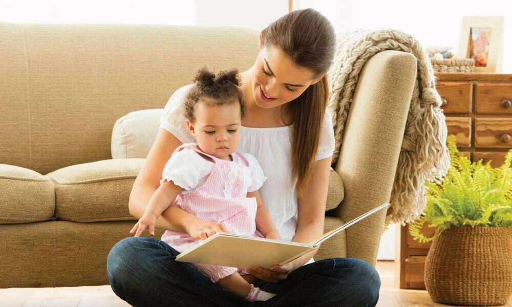 Small child reading with mother