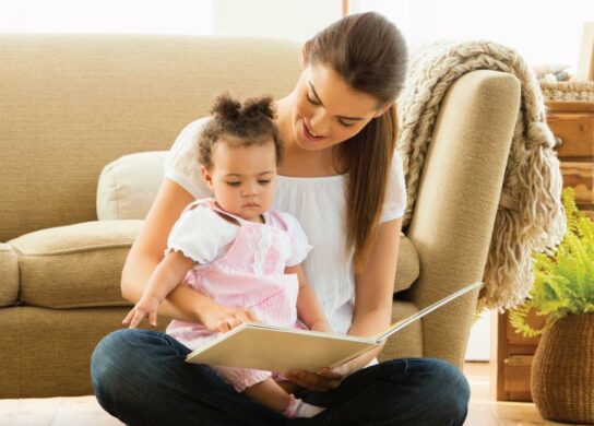 Small child reading with mother