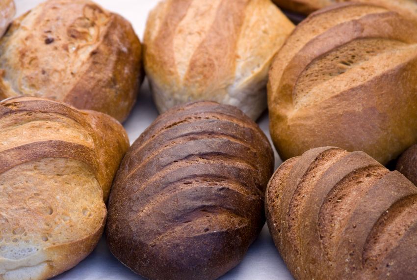 Six loaves of assorted bread which are different colors of brown