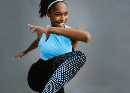 Woman stretching in a blue shirt and leggings