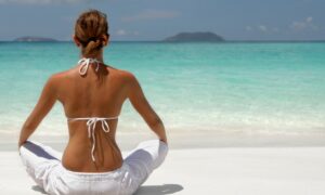 Image of woman sitting cross-legged on the beach